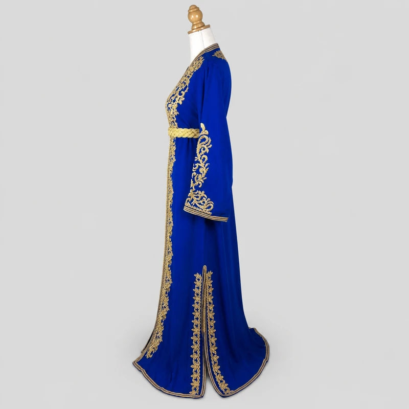 Vue de côté d’un caftan bleu en crêpe de soie avec motifs dorés brodés et coupe élégante, tenue orientale raffinée pour mariage et cérémonie.