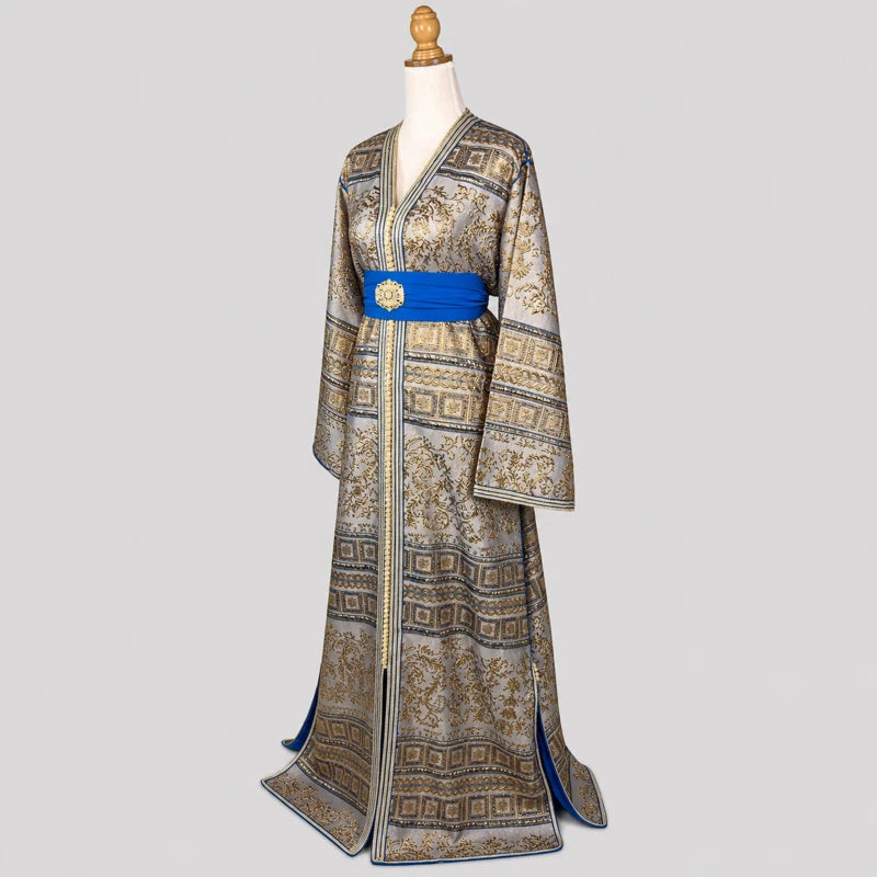Vue de profil du caftan brocard vintage gris argenté et doré avec ceinture bleue satinée, motifs orientaux raffinés et coupe élégante pour cérémonie.