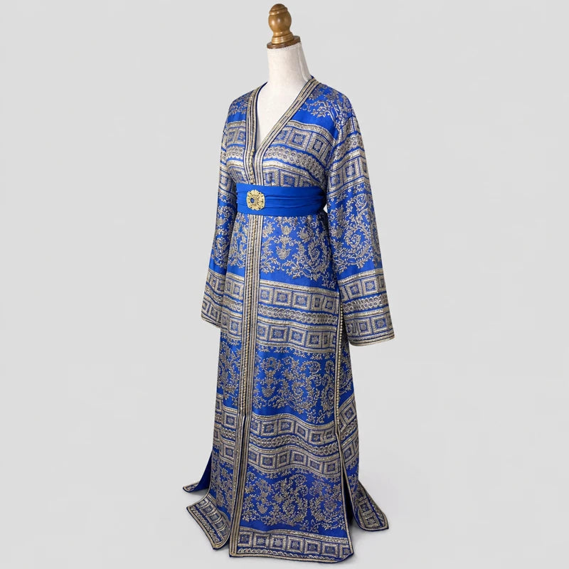 Vue de profil d’un caftan brocart bleu et doré vintage en crêpe de soie avec motifs orientaux raffinés et ceinture bleue élégante pour mariage et cérémonie.