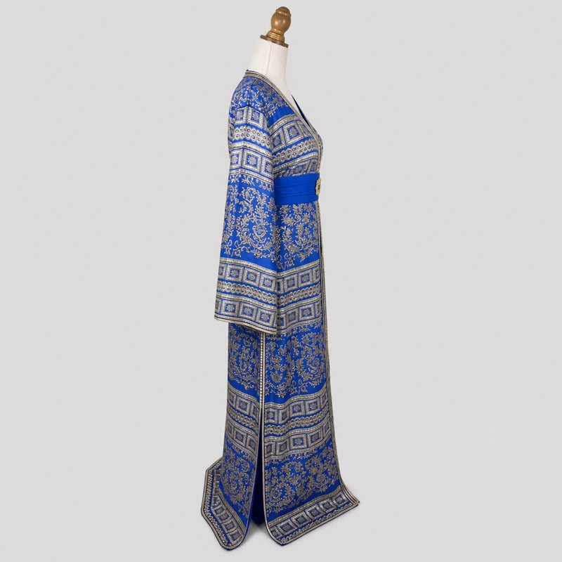 Vue de profil d’un caftan brocart bleu et doré vintage en crêpe de soie avec motifs floraux orientaux et finitions dorées élégantes pour cérémonie marocaine.
