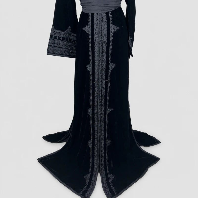 Détail du bas d’un caftan femme en velours noir avec broderies artisanales raffinées et coupe longue élégante, robe marocaine idéale pour mariage, soirée orientale et cérémonie chic.