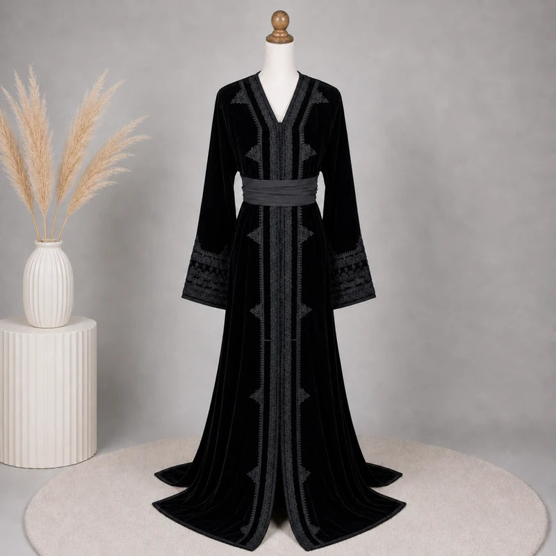 Caftan femme en velours noir brodé présenté dans un décor élégant avec finitions artisanales et ceinture assortie, robe marocaine raffinée idéale pour mariage, cérémonie et soirée orientale.