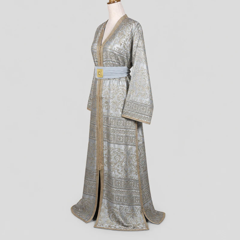 Vue de profil d’un caftan gris argenté en brocard avec motifs dorés et ceinture élégante, robe orientale traditionnelle raffinée pour mariage et cérémonie.