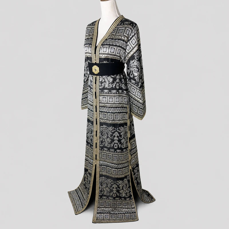 Caftan marocain brocart noir vintage avec motifs argentés et finitions dorées, vue angle élégante avec ceinture noire raffinée pour femme.