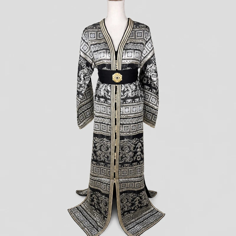 Caftan marocain vintage noir avec brocart argenté et doré, manches larges élégantes et ceinture raffinée pour tenue orientale femme.