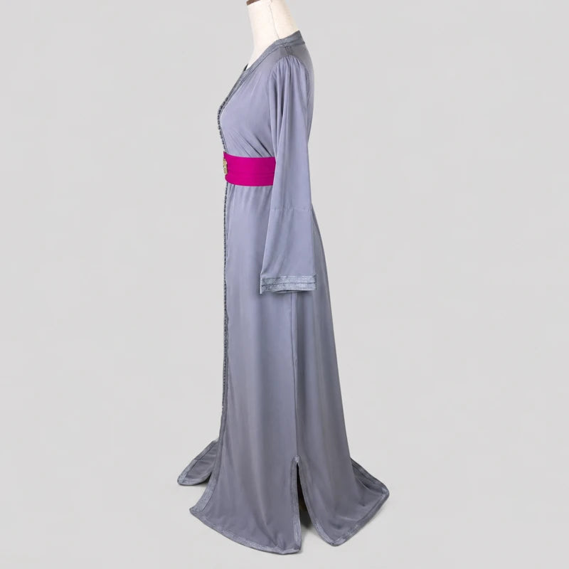 Vue de profil d’un caftan marocain simple gris en crêpe fluide avec doublure fuchsia et ceinture assortie, coupe longue élégante et finitions traditionnelles marocaines présentées sur mannequin.