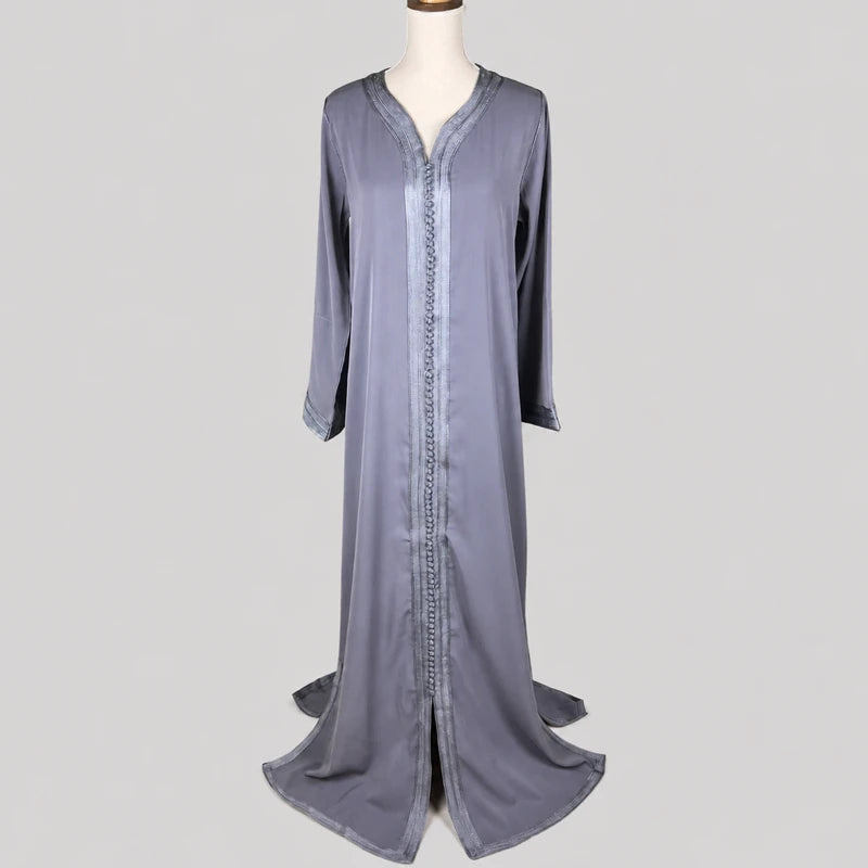 Caftan marocain simple gris en tissu crêpe fluide avec finitions traditionnelles, doublure fuchsia et ceinture assortie, présenté sur mannequin pour une tenue élégante et raffinée.