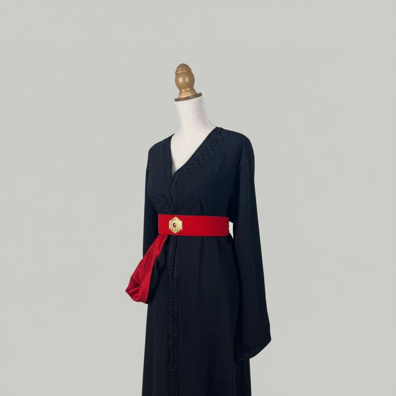 caftan marocain noir avec ceinture rouge et broderies discrètes, vue de profil élégante