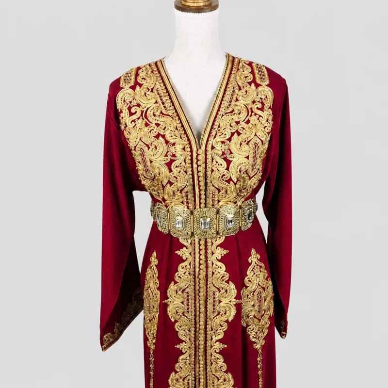 Zoom sur le buste d’un caftan rouge en crêpe de soie avec broderies dorées et ceinture ornée, finitions élégantes pour tenue de mariage ou cérémonie orientale