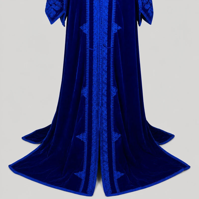 Détail du bas d’un caftan marocain bleu royal en velours avec finitions brodées élégantes et coupe longue fluide pour femme.