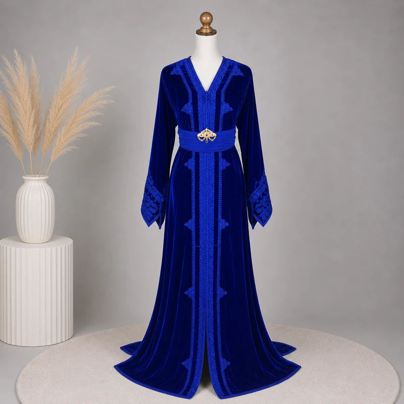 Caftan marocain femme en velours bleu royal avec broderies élégantes ton sur ton et ceinture raffinée, présenté en vue complète.