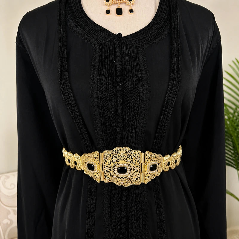 Ceinture mdamma marocaine dorée avec pierres noires portée sur un caftan noir traditionnel pour mariage et cérémonie