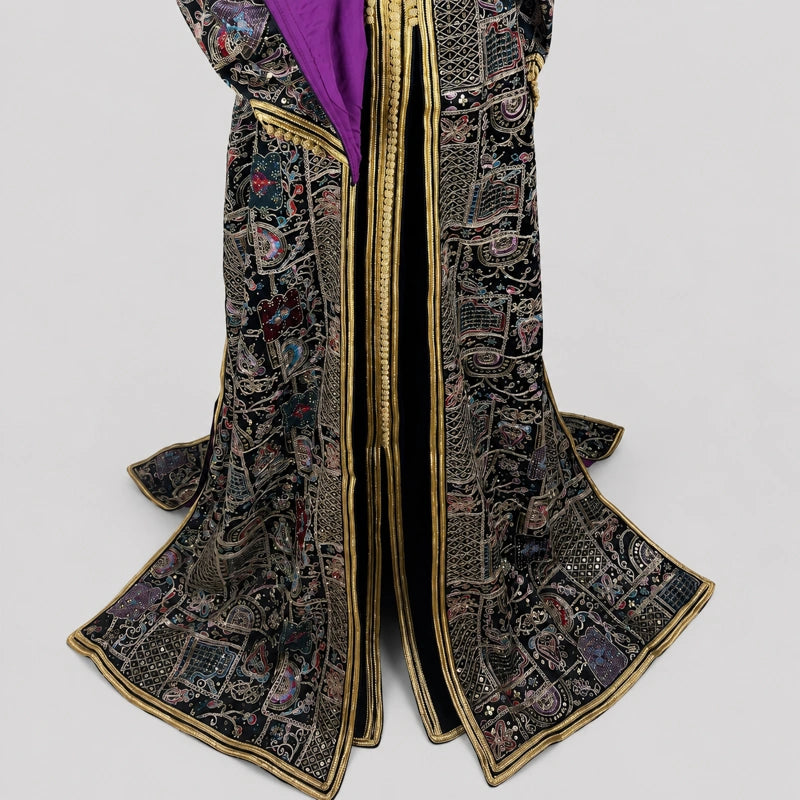 Détail du bas de takchita noire brodée avec doublure violette et finitions dorées, caftan marocain haut de gamme aux motifs orientaux raffinés, robe traditionnelle élégante pour femme idéale pour mariage, soirée orientale et cérémonie marocaine.