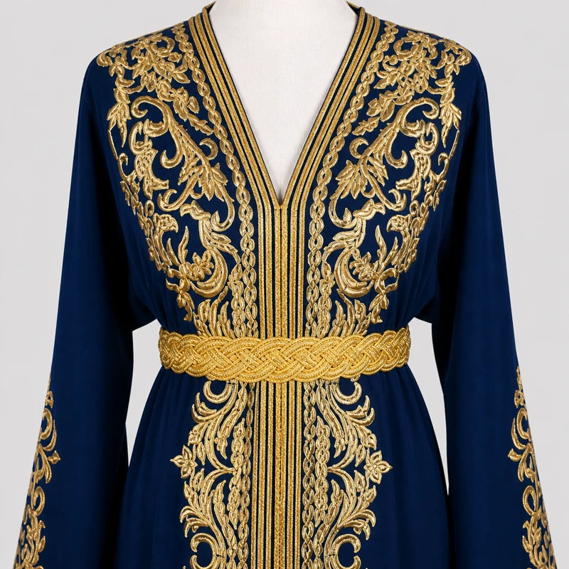 Détail des broderies dorées sur un caftan bleu en crêpe de soie avec ceinture élégante et finitions raffinées, tenue orientale de mariage et cérémonie.