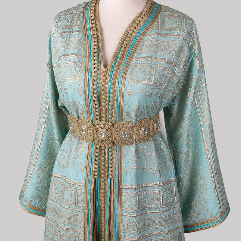 Détail du haut d'une takchita marocaine vert d'eau en brocard brodé doré avec ceinture traditionnelle et finitions artisanales de luxe.