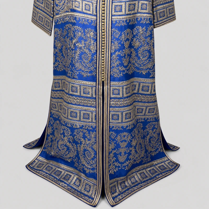 Détail du bas d’un caftan brocart bleu et doré vintage avec motifs orientaux raffinés et finitions dorées élégantes en crêpe de soie.