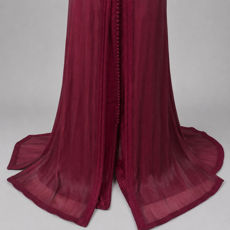 Détail du bas d’une takchita bordeaux en organza avec finitions marocaines élégantes et tissu fluide