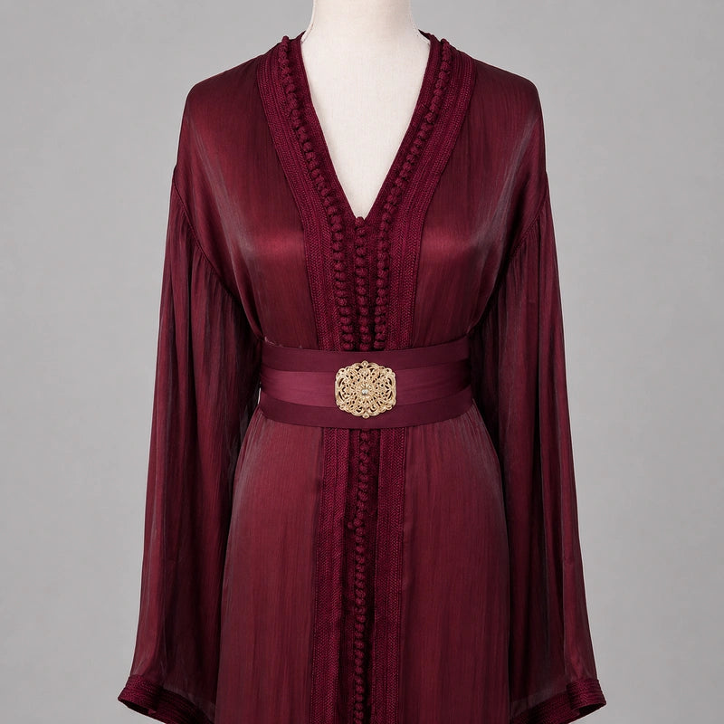 Détail du haut d’une takchita bordeaux en organza avec broderies marocaines raffinées et ceinture élégante