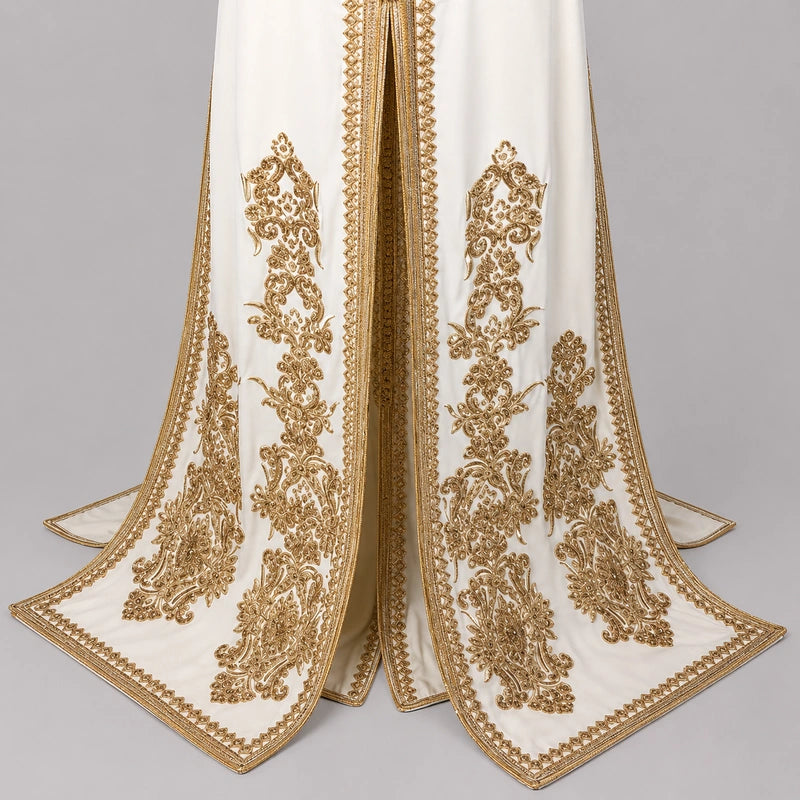 Détail du bas d’une takchita mariée blanc cassé en crêpe de soie avec broderies dorées marocaines raffinées