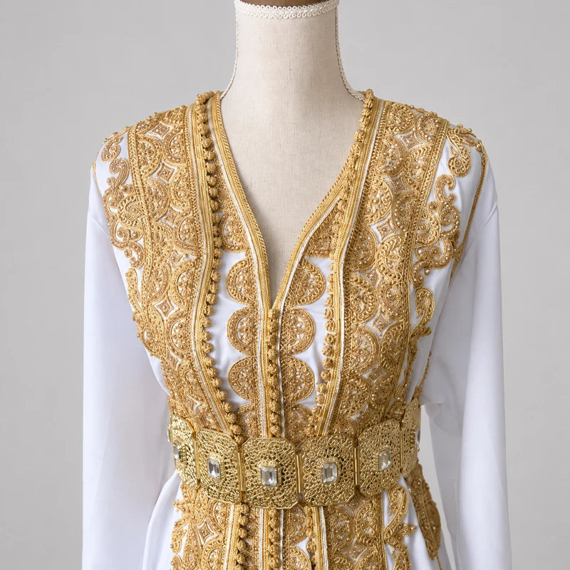 Détail des broderies dorées d’une takchita de mariée blanche en crêpe de soie avec ceinture travaillée, robe marocaine traditionnelle haut de gamme