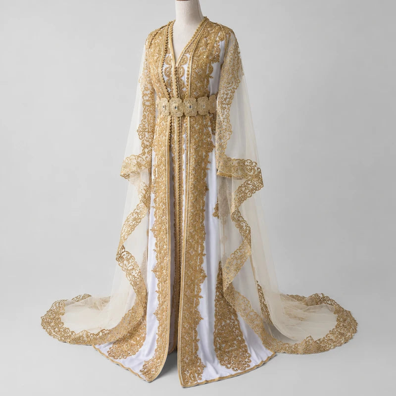 Takchita de mariée blanche en crêpe de soie avec broderies dorées artisanales et voile raffiné, vue 3/4 d’une robe marocaine traditionnelle élégante