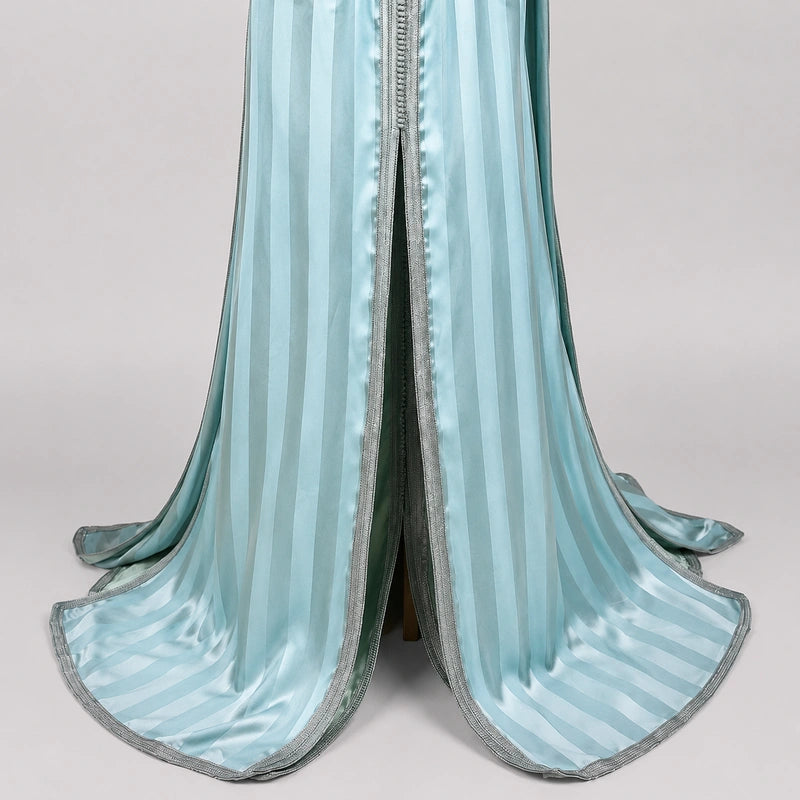 Détail du bas d’une takchita marocaine bleu givré en tlija avec finitions satinées et rayures élégantes