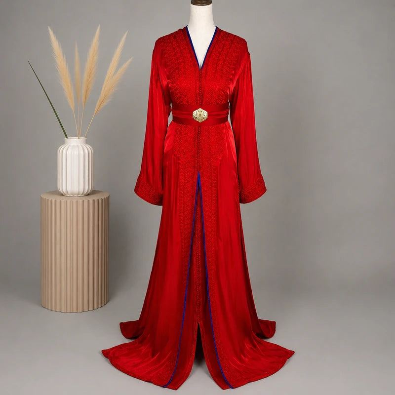 Takchita marocaine rouge et bleu roi en organza de mariage présentée sur mannequin dans une mise en scène élégante, avec broderies artisanales et ceinture traditionnelle.