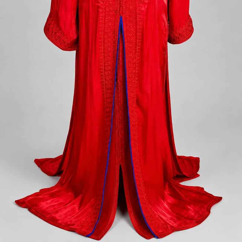 Détail du bas d'une takchita marocaine rouge et bleu roi en organza de mariage mettant en valeur les broderies artisanales, les finitions raffinées et la coupe fluide.