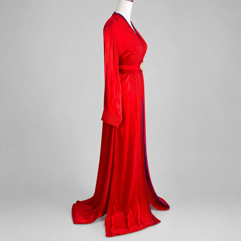 Vue de profil d'une takchita marocaine rouge et bleu roi en organza de mariage avec manches longues, broderies raffinées et ceinture traditionnelle pour cérémonie et mariage.