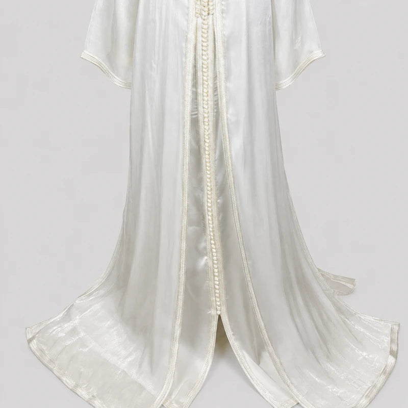 Détail bas takchita organza blanc cassé avec tissu fluide satiné, finition élégante et transparence légère orientale