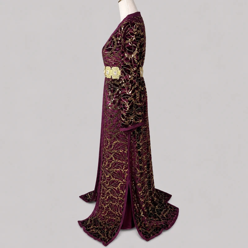 Takchita velours bordeaux à motifs dorés vue profil avec tissu brillant, ceinture orientale et détails lumineux élégants