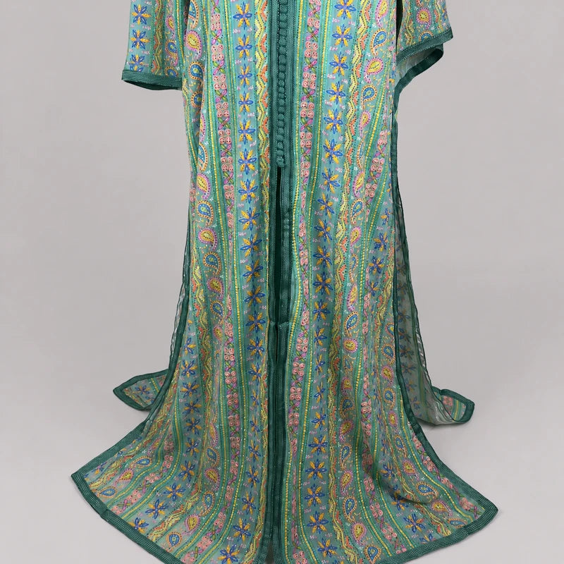 Détail du bas d’une takchita verte brodée en sari vintage avec motifs floraux et arabesques colorées, robe marocaine traditionnelle élégante