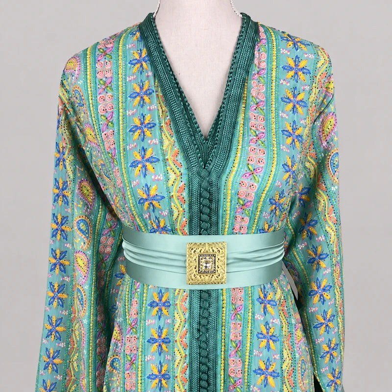 Détail du buste d’une takchita verte brodée en sari vintage avec motifs floraux bleus et ceinture satinée, tenue marocaine élégante et raffinée