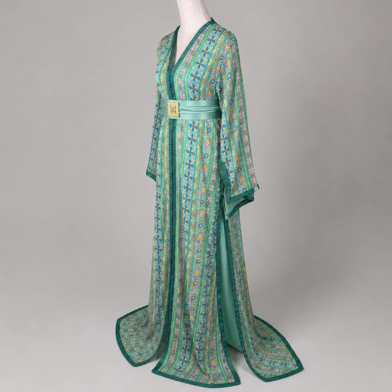 Vue 3/4 d’une takchita verte brodée en sari vintage avec motifs floraux colorés, manches fluides et ceinture satinée, tenue marocaine élégante sur mannequin