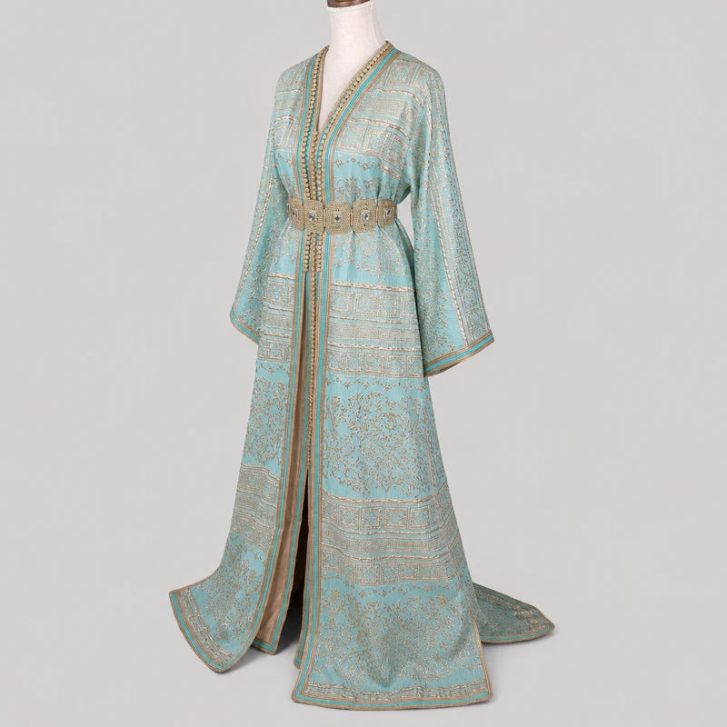 Takchita marocaine vert d'eau en brocard brodé doré présentée en vue de face légèrement inclinée, avec ceinture traditionnelle et finitions artisanales élégantes.